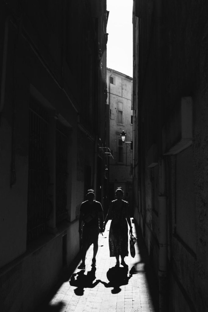 Deux silhouettes à contre-jour au fond d'une ruelle étroite